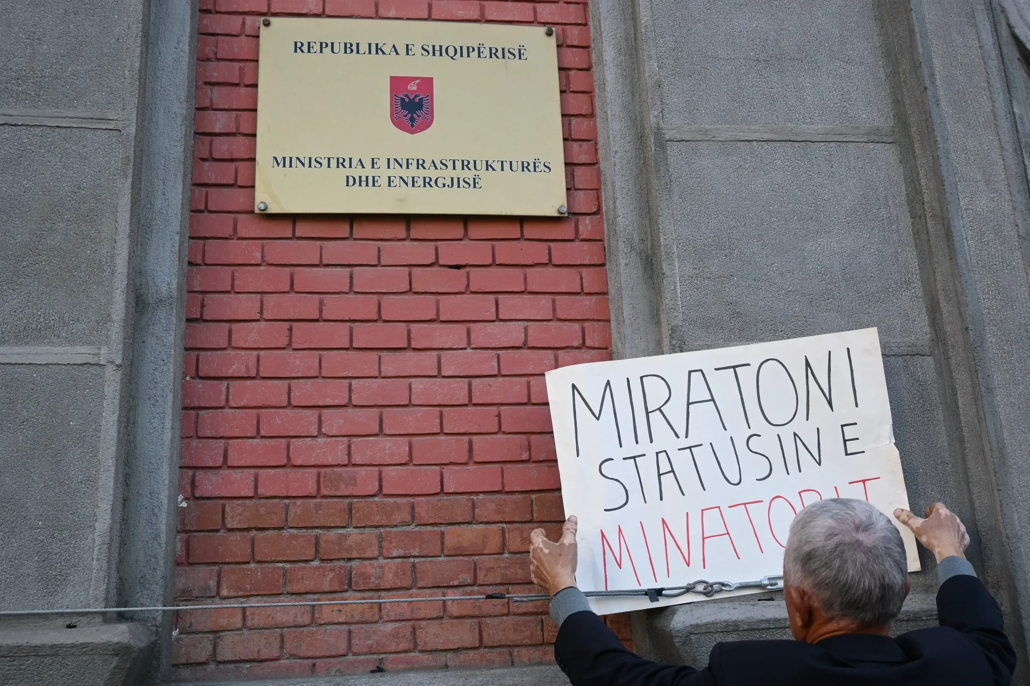 Nje minator duke vendosur nje pankarte qe shkruan 'Miartoni Statisin e Minatorit' te Ministria e Infrastuktures dhe Energjitikes