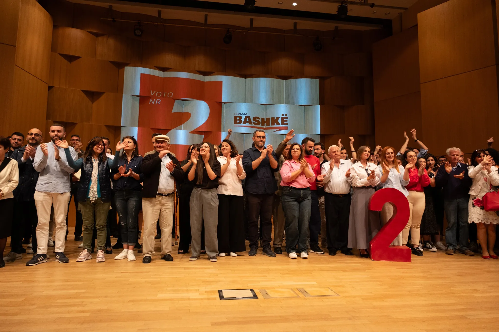 Kandidatët e Lëvizjes BASHKË në skenë duke përshendetur pjesëmarrësit pas takimit përmbyllës të fushatës.